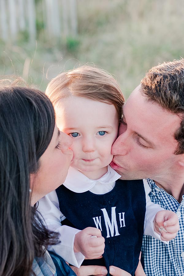 Parents kissing little boy by Nantucket Family Photographer
