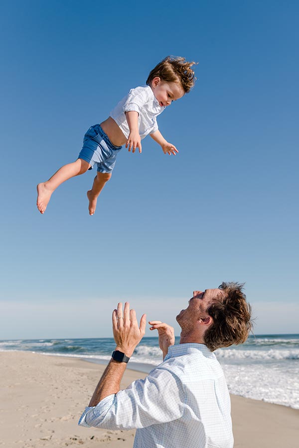 LIttle boy being thrown in the air by dad