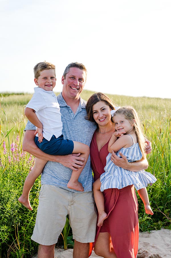 Family of 4 smiling at camera